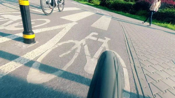 Вид ззаду велосипеда, що швидко рухається міською велосипедною дорогою — стокове фото