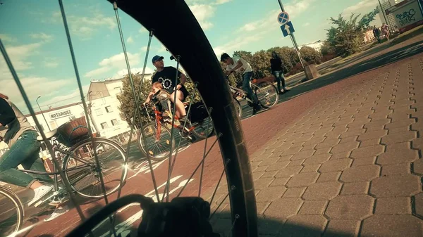 ADVERTÊNCIA, POLÓNIA - JULHO 18, 2017. Ciclistas na travessia da cidade e roda de bicicleta close-up — Fotografia de Stock