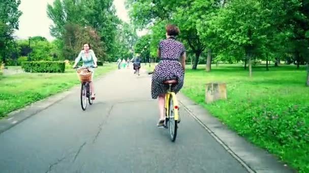 Warszawa, Polen - 11 juli 2017. Ung kvinna i klänning cykling längs park road — Stockvideo