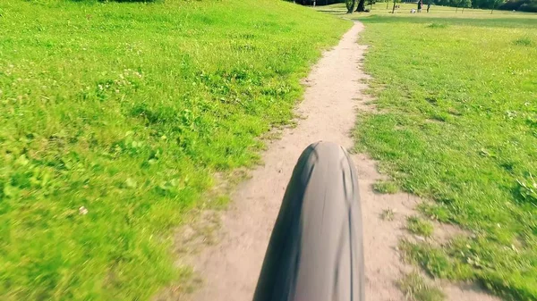 Vista trasera de una bicicleta que se mueve rápido a lo largo del sendero del parque — Foto de Stock