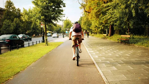 Невідомий чоловік їде по міській велосипедній доріжці після літнього дощу — стокове фото