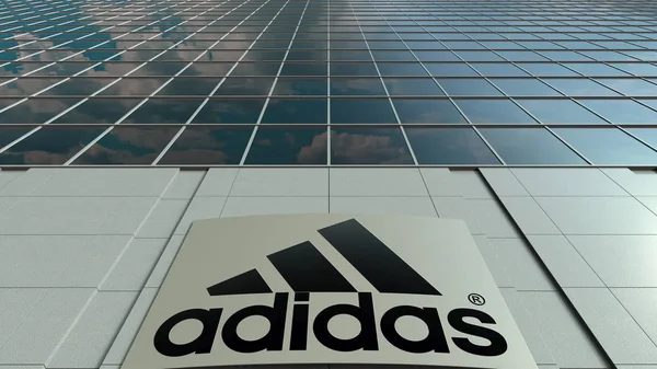 Panneau de signalisation avec inscription et logo Adidas. Façade moderne d'immeubles de bureaux. Editorial rendu 3D — Photo