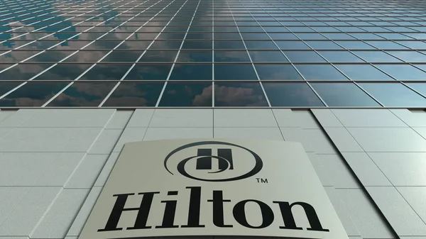 Placa de sinalização com Hilton Hotels Resorts logotipo. Fachada de edifício de escritório moderno. Renderização 3D editorial — Fotografia de Stock