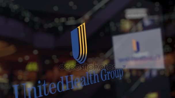 Το λογότυπο Unitedhealth ομάδα στην το ποτήρι ενάντια θολή επιχειρηματικό κέντρο. Συντακτική 3d rendering — Αρχείο Βίντεο