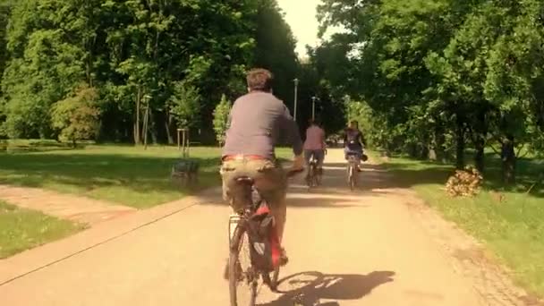 Gente desconocida en bicicleta a lo largo del camino del parque de verano — Vídeos de Stock