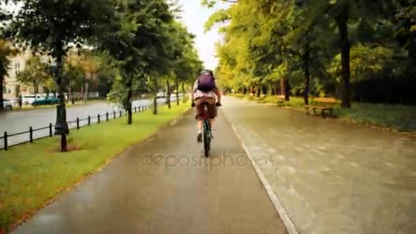 Hombre desconocido ciclismo a lo largo de carril bici urbano después de la lluvia de verano — Vídeo de stock