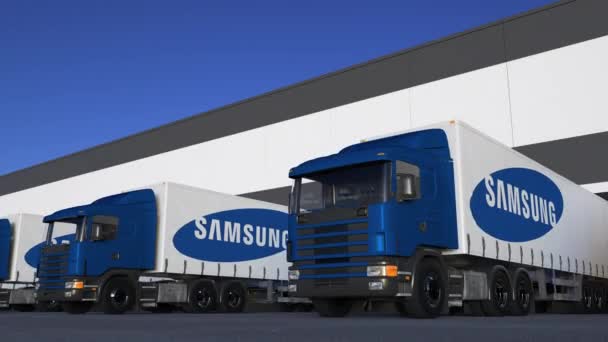 Camiones semirremolques de carga con el logotipo de Samsung cargando o descargando en el muelle del almacén, bucle sin fisuras. Animación Editorial 4K — Vídeos de Stock