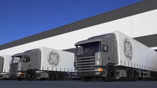 Semirremolques de carga con el logotipo de General Electric GE cargando o descargando en el muelle del almacén, bucle sin fisuras. Animación Editorial 4K — Vídeo de stock
