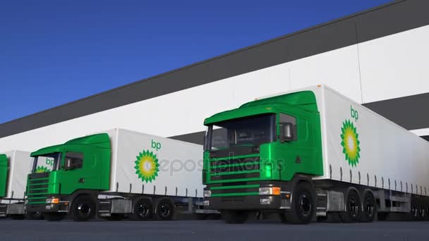 Semi-caminhões de carga com o logotipo da BP carregando ou descarregando na doca do armazém, loop sem costura. Editorial 4K animação — Vídeo de Stock