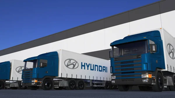 Грузовые полугрузовики с логотипом Hyundai Motor Company погрузка или разгрузка на складском причале. Редакционная 3D рендеринг — стоковое фото