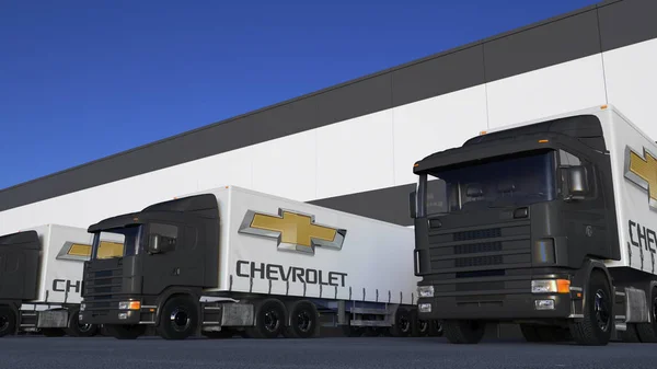 Грузовые полуприцепы с логотипом Chevrolet, погрузка или разгрузка на складе. Редакционная 3D рендеринг — стоковое фото