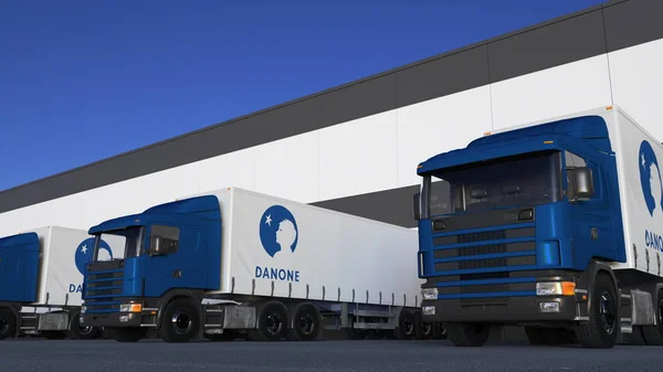 Frakt semi lastbilar med Danone logotyp lastning eller lossning på lager dock. Redaktionella 3d-rendering — Stockfoto