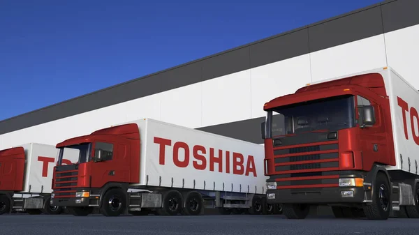 Sattelschlepper mit dem Logo der Toshiba Corporation beim Be- oder Entladen im Lagerdock. redaktionelles 3D-Rendering — Stockfoto
