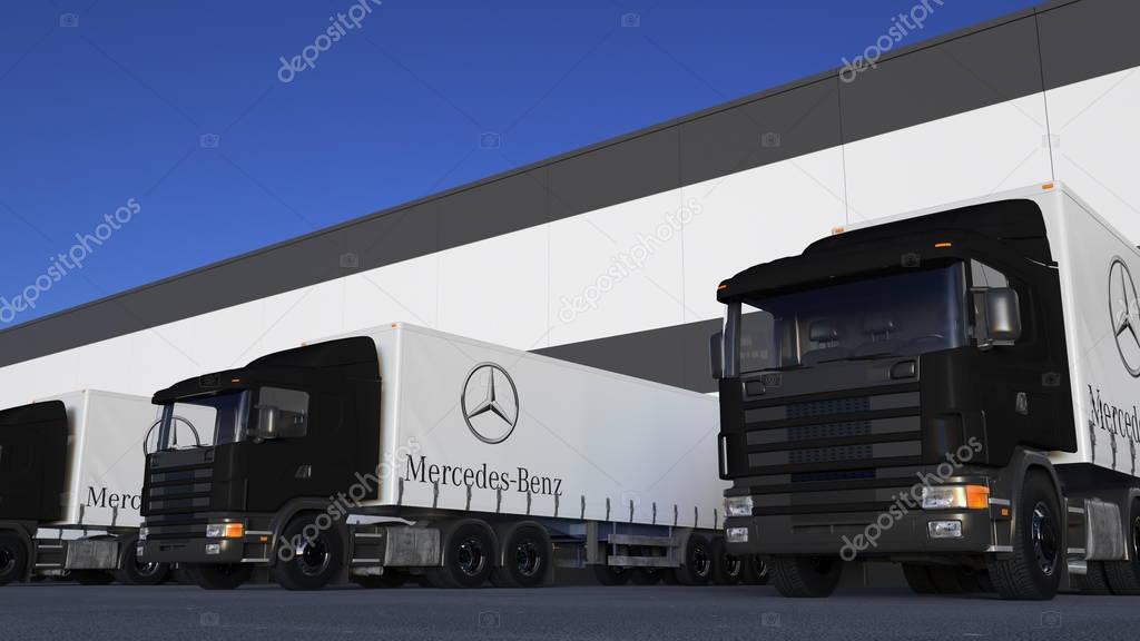 Freight semi trucks with Mercedes-Benz Company logo loading or unloading at warehouse dock. Editorial 3D