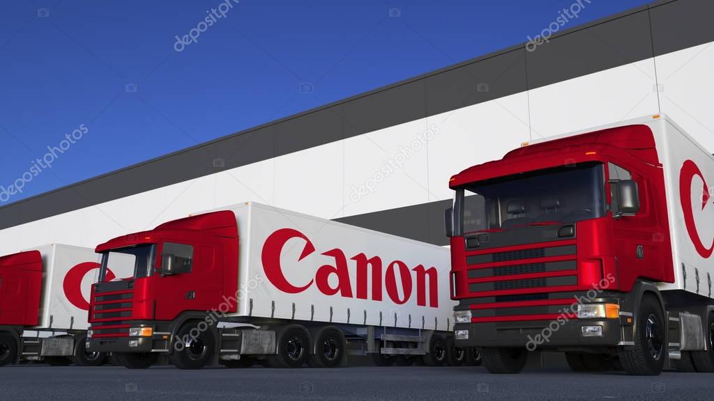 Freight semi trucks with Canon Inc. logo loading or unloading at warehouse dock. Editorial 3D