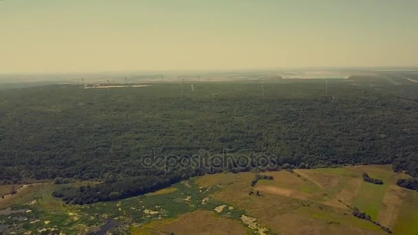 Bortfall av vindmøller i luften i skogområdet. Begrepet grønn energiproduksjon – stockvideo