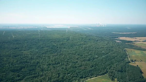 Vista aérea de geradores de vento contra pilhas fumantes de uma usina tradicional. Produção de energia verde, conceitos de tecnologia novos e antigos, limpos e poluentes — Fotografia de Stock