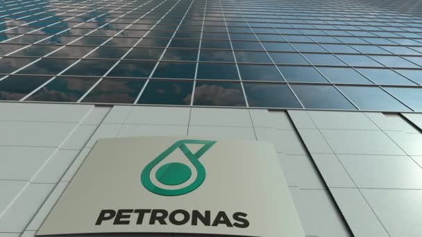 Panneau de signalisation avec logo Petroliam Nasional Berhad PETRONAS. Immeuble de bureaux moderne façade time lapse. Editorial rendu 3D — Video