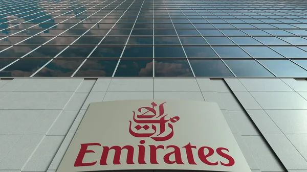 Tablero de señalización con logotipo de Emirates Airline. Moderna fachada del edificio de oficinas. Representación Editorial 3D —  Fotos de Stock