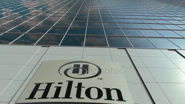 Papan nama dengan logo Hilton Hotels Resorts. Bangunan perkantoran modern, selang waktu. Perenderan 3D Editorial — Stok Video
