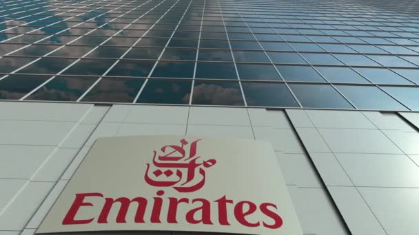 Вывеска с логотипом Emirates Airline. Прошло время фасада современного офисного здания. Редакционная 3D рендеринг — стоковое видео