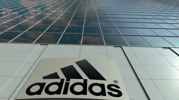 Panneau de signalisation avec inscription et logo Adidas. Immeuble de bureaux moderne façade time lapse. Editorial rendu 3D — Video