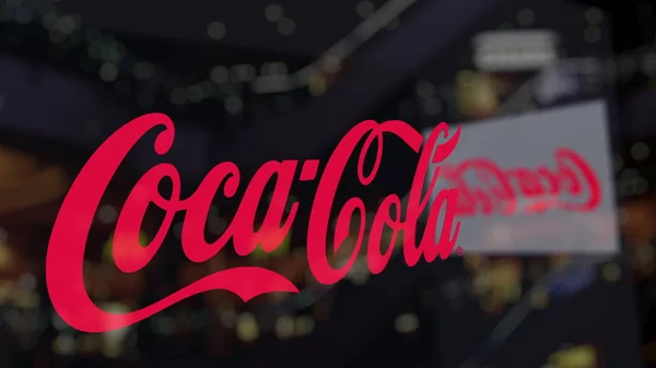 Logo Coca-Cola pada kaca melawan pusat bisnis kabur. Perenderan 3D Editorial — Stok Foto