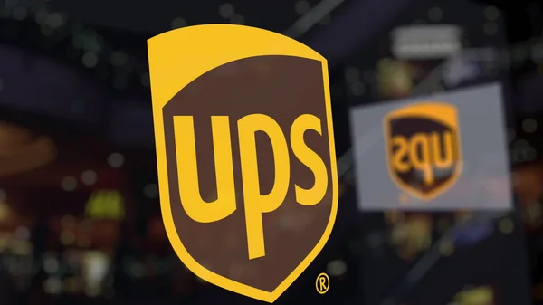 Logo UPS United Parcel Service pada kaca terhadap pusat bisnis kabur. Perenderan 3D Editorial — Stok Foto