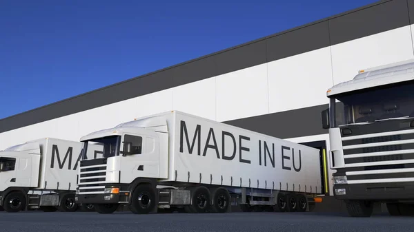 Грузовые полувагоны с надписью "MADE IN EU" на погрузке или разгрузке прицепа. 3D рендеринг автомобильных грузов — стоковое фото