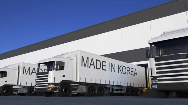 Semi-caminhões de carga com legenda MADE IN KOREA no carregamento ou descarga do reboque. Transporte rodoviário de carga renderização 3D — Fotografia de Stock