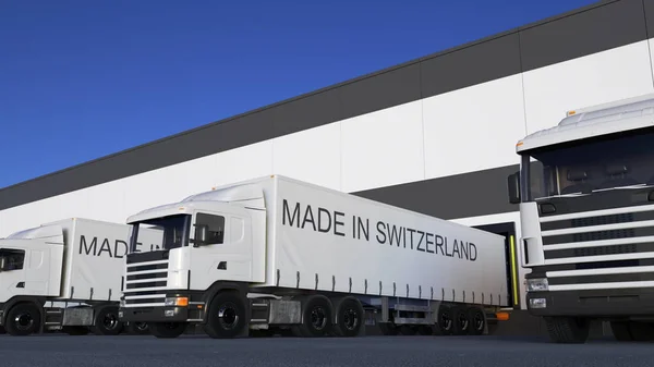 Грузовые полувагоны с надписью "MADE IN SWITZERLAND" на погрузке или разгрузке прицепа. 3D рендеринг автомобильных грузов — стоковое фото