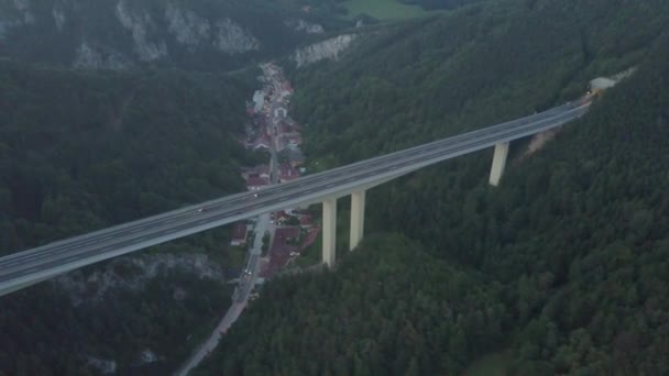 Αεροφωτογραφία του Ευρωπαϊκού αυτοκινητόδρομου γέφυρα πάνω από την μικρή πόλη το βράδυ — Αρχείο Βίντεο
