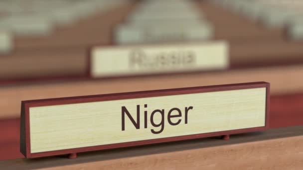 Firma del nome Niger tra le diverse targhe dei paesi presso l'organizzazione internazionale. Rendering 3D — Video Stock