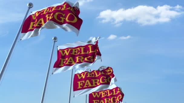 Bandiere sventolanti con logo Wells Fargo contro il cielo, anello senza cuciture. Animazione editoriale 4K — Video Stock