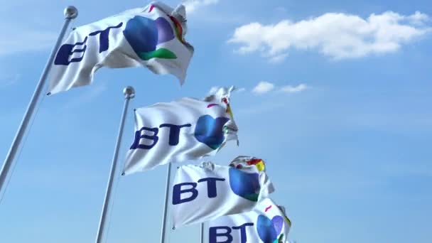 Ondeando banderas con el logotipo de British Telecom BT contra el cielo, lazo sin costuras. Animación editorial 4K — Vídeo de stock
