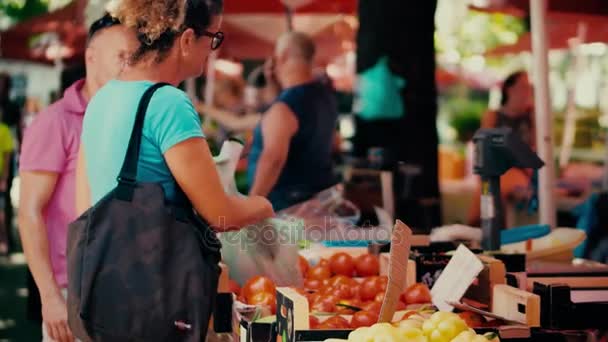 Pula, Kroatië - 4 augustus 2017. Vrolijke vrouw kopen tomaten op lokale boeren markt — Stockvideo