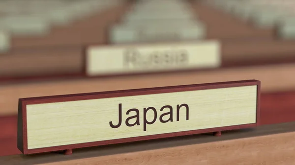 Firma del nome del Giappone tra le diverse targhe dei paesi presso l'organizzazione internazionale. Rendering 3D — Foto Stock