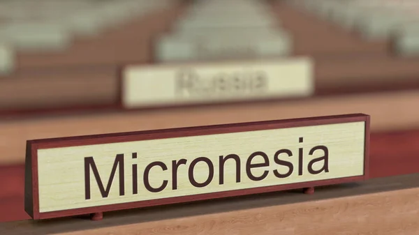 Firma del nome della Micronesia tra le targhe dei diversi paesi presso l'organizzazione internazionale. Rendering 3D — Foto Stock