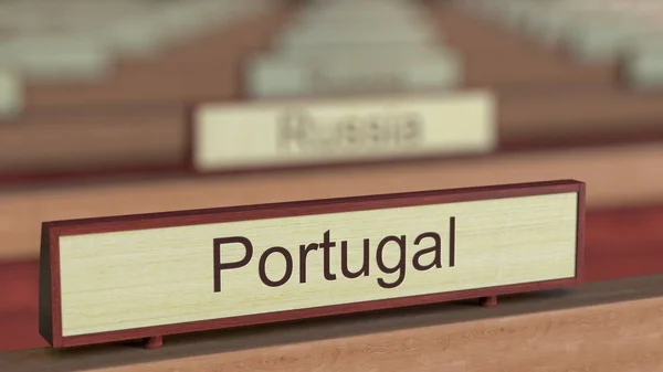 Portugal nome assinar entre diferentes placas de países na organização internacional. Renderização 3D — Fotografia de Stock