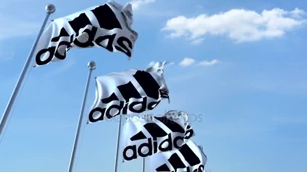 Ondeando banderas con el logotipo de Adidas contra el cielo, lazo sin costuras. Animación editorial 4K — Vídeos de Stock