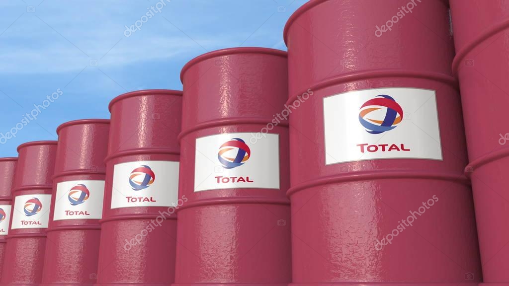 Row of metal barrels with Total logo against sky