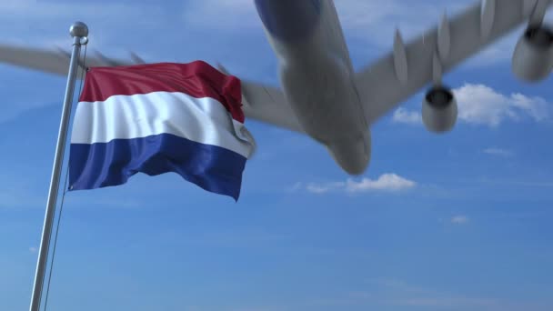 Verkehrsflugzeug landet hinter schwenkender holländischer Flagge. Reise in die Niederlande konzeptionelle Animation — Stockvideo