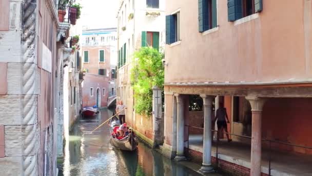 VENECIA, ITALIA - 8 de agosto de 2017. Pareja joven caminando a lo largo del canal veneciano y haciendo fotos de la famosa góndola — Vídeo de stock