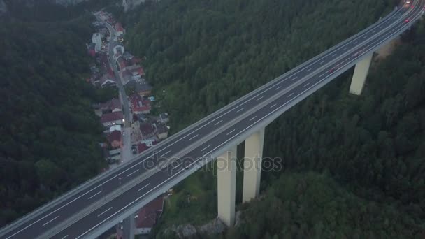 Aerial shot of a highway bridge and a tunnel in mountains in the evening — Stock Video