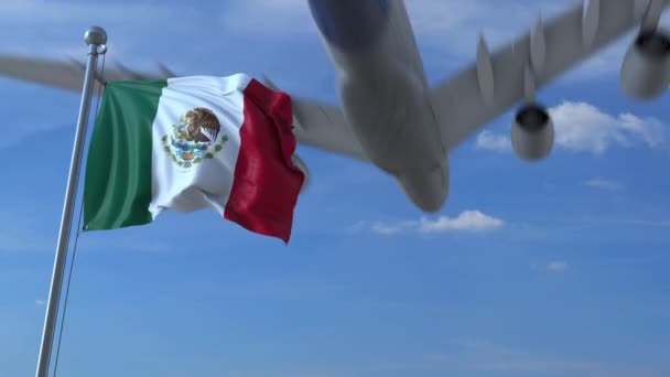 Commercial airplane landing behind waving Mexican flag — Stock Video