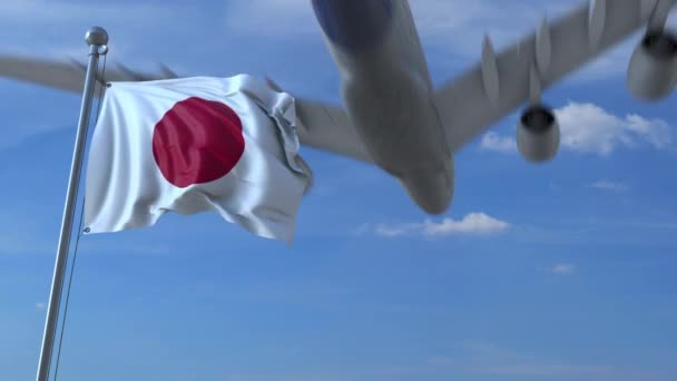 Avión comercial aterrizando detrás ondeando bandera japonesa — Vídeo de stock