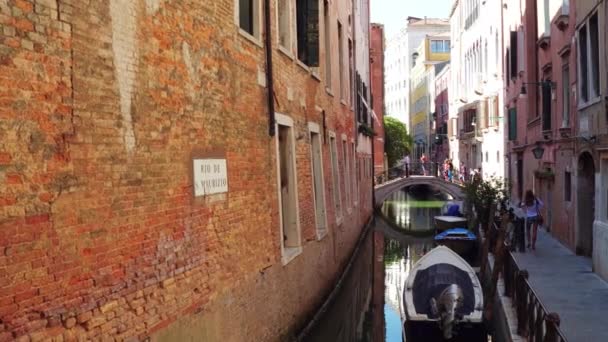 ВЕНЕЦИЯ, ИТАЛИЯ - 8 августа 2017 года. Венецианский канал и пешеходный мост и набережная — стоковое видео