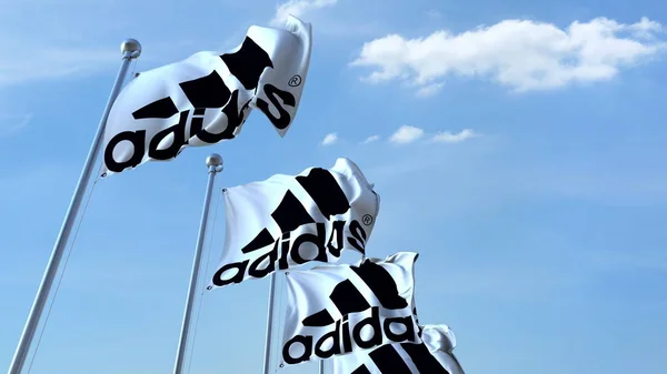 Bandiere sventolanti con logo Adidas contro il cielo, rendering editoriale 3D — Foto Stock