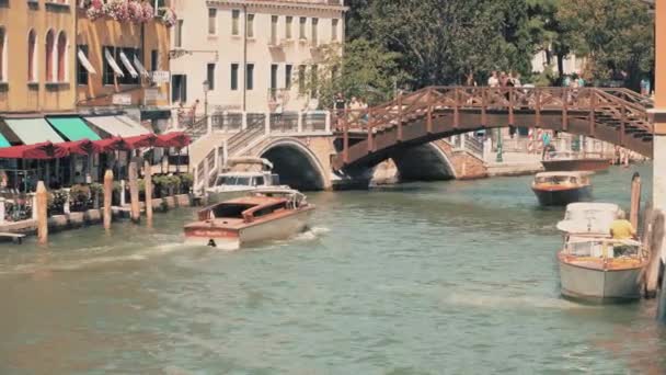 VENECIA, ITALIA - 8 de agosto de 2017. Tráfico de agua en el canal veneciano y pequeño puente peatonal — Vídeo de stock