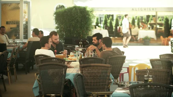 PULA, CROATIA - AUGUST 4, 2017. Young male friends eat out in a street cafe — Stock Photo, Image